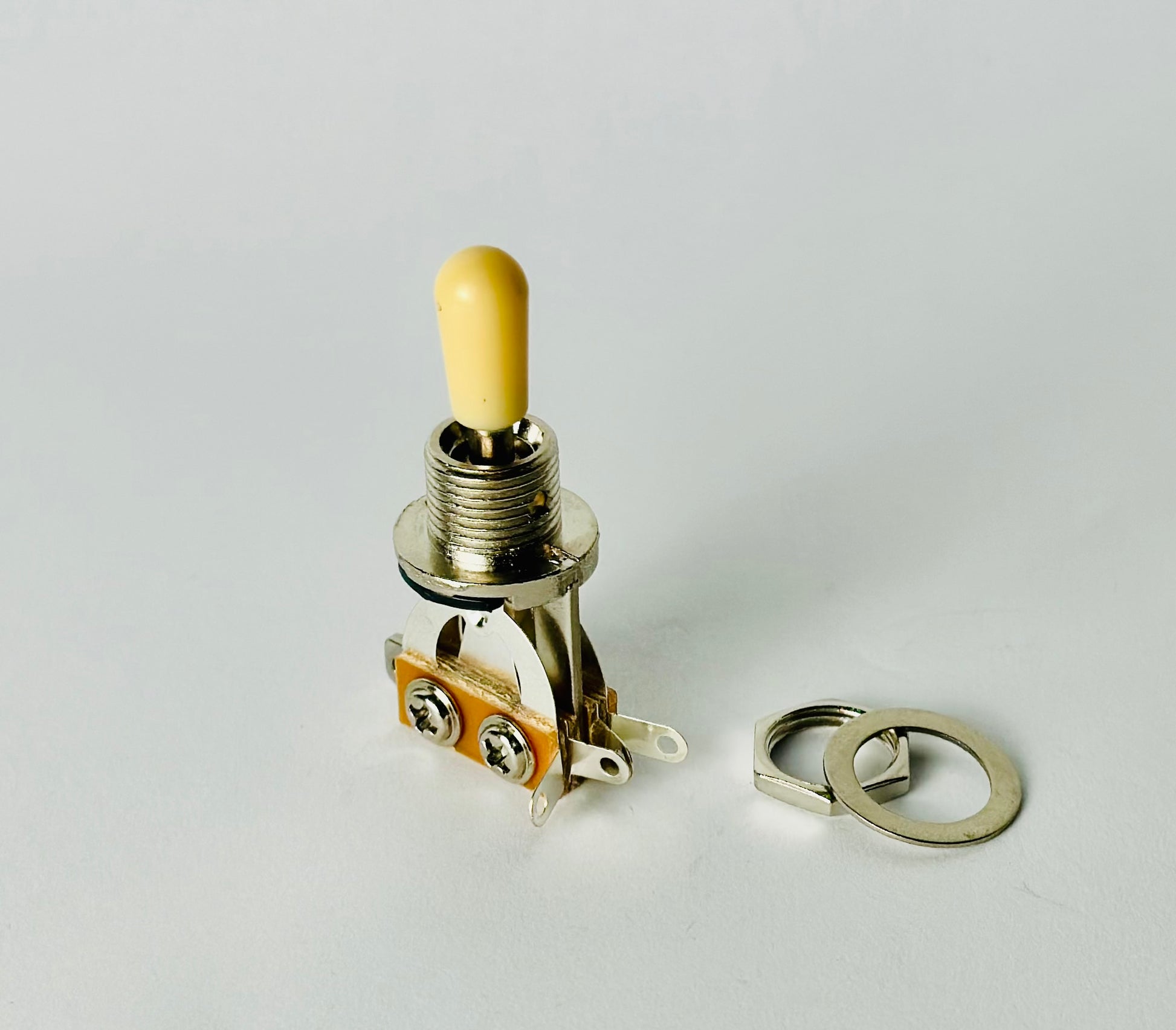 Chrome 3-way toggle switch with cream tip showing copper contact plate and terminals